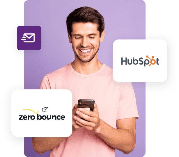 A man in a pink shirt looks down at his phone and smiles next to ZeroBounce and HubSpot logos