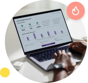 An over the shoulder shot of hands typing on a laptop that shows the ,[object Object], dashboard on screen.