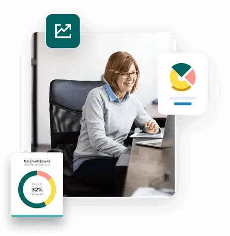 Mujer sentada en un escritorio sonriendo y mirando su computadora portátil usando ZeroBounce Captura todos los correos electrónicos para aumentar el ROI de su correo electrónico.