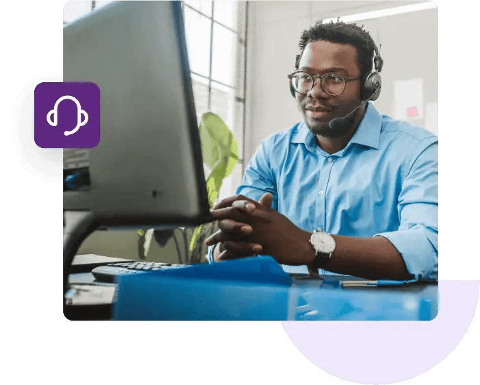 Customer support agent at his desk talks to a customer