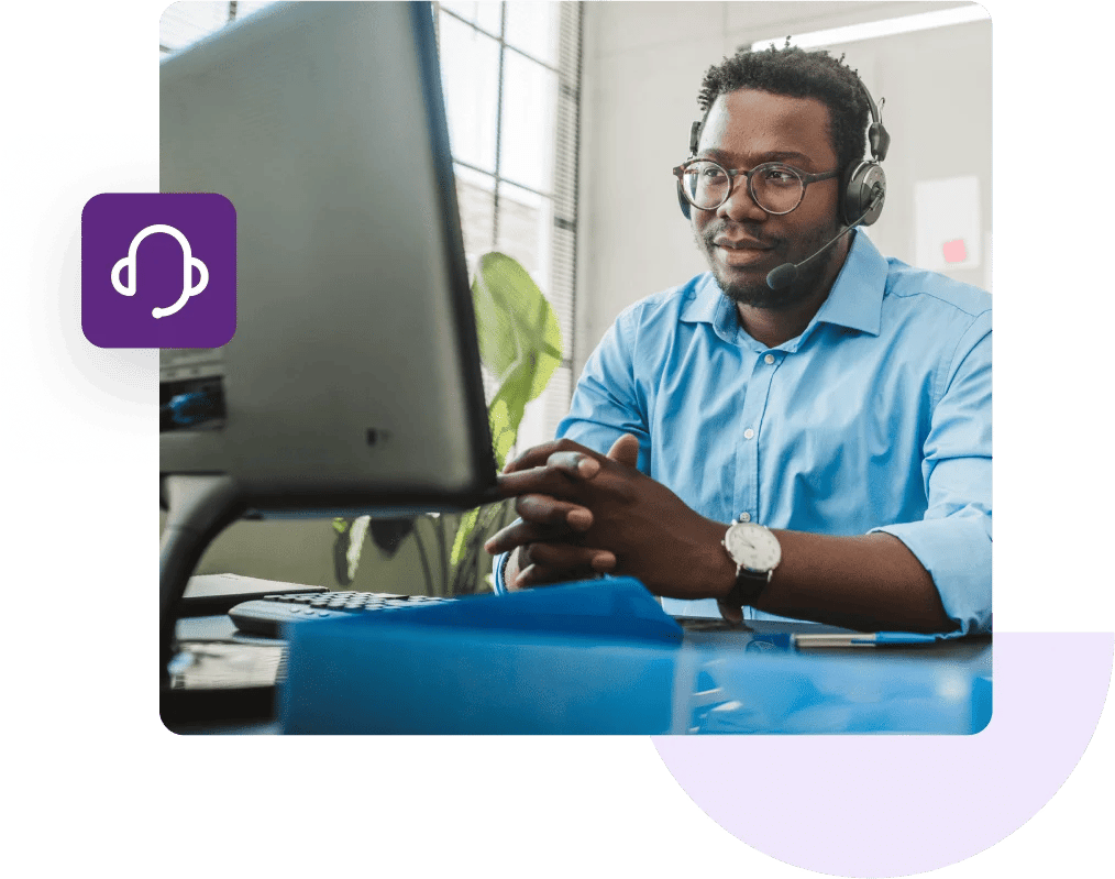 Support agent wearing a headset sitting at his desk and observing his computer monitor