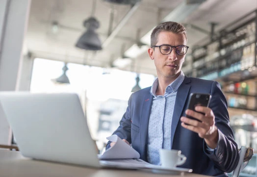 Man reviewing his email list for clean emails via mobile and laptop