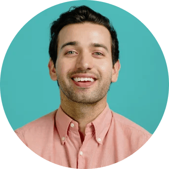 Man in pink shirt smiling at the camera