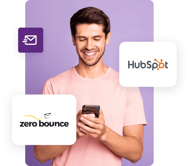 A man in a pink shirt looks down at his phone and smiles next to ZeroBounce and HubSpot logos