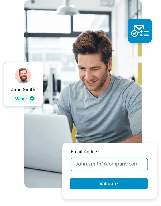 Man smiling looking down at his computer, surrounded by a valid email check for john.smith@company.com