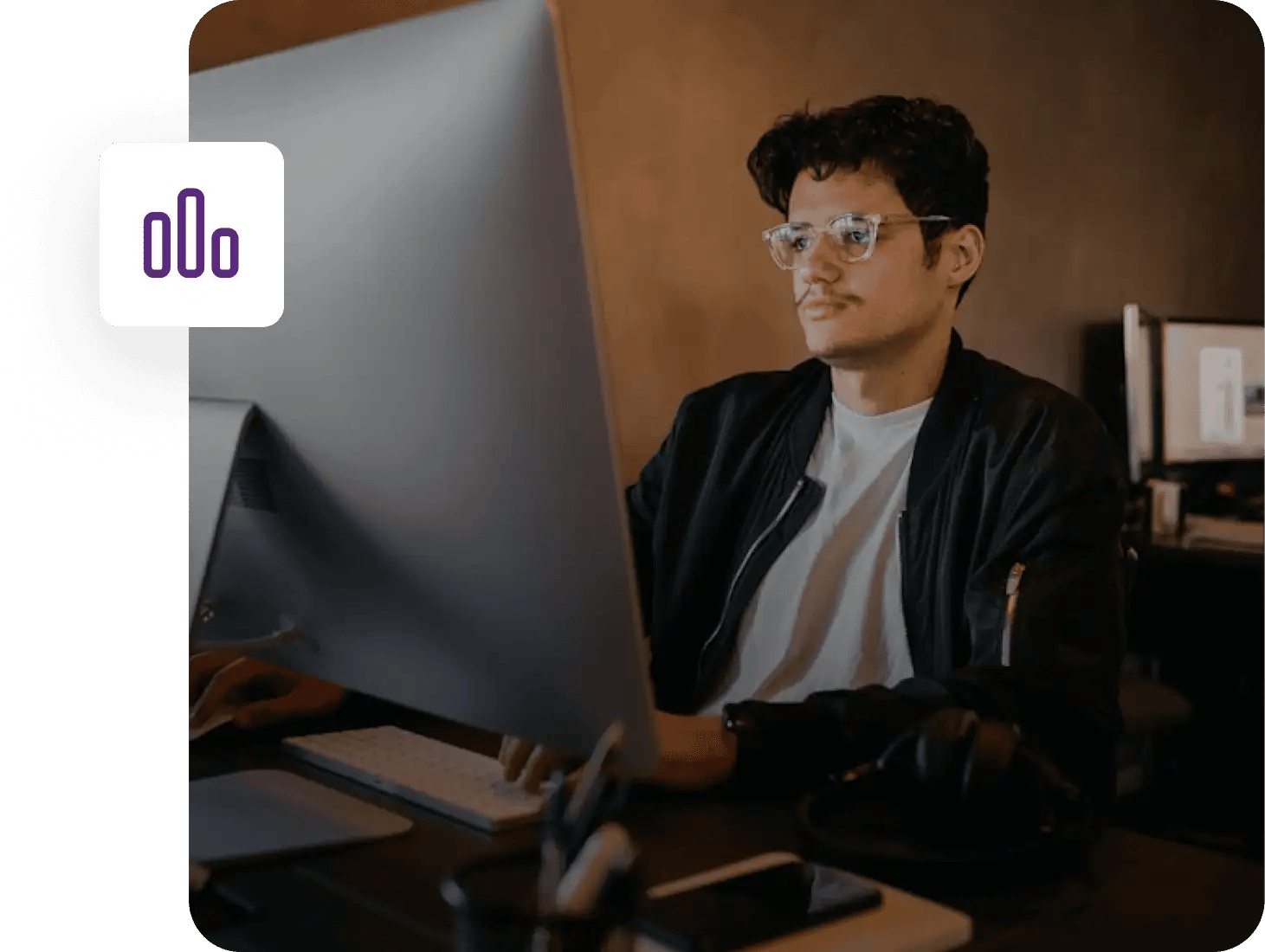 A man smiling at his desk reviewing ZeroBounce case studies.