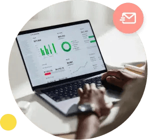 Un primer plano de manos escribiendo en una computadora portátil que muestra diferentes tablas y gráficos.