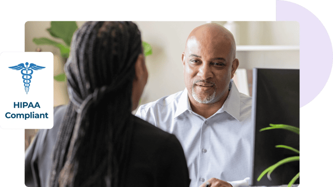 Un hombre y una mujer se sientan uno frente al otro en un escritorio para hablar sobre la seguridad del correo electrónico, acompañados de un logotipo de cumplimiento con la HIPAA.