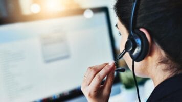 Marketer uses call attribution and email validation to increase ROI while on phone headset in front of computer screen.