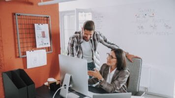 Male and female colleague sit before computer to allow Gong Enrich data.