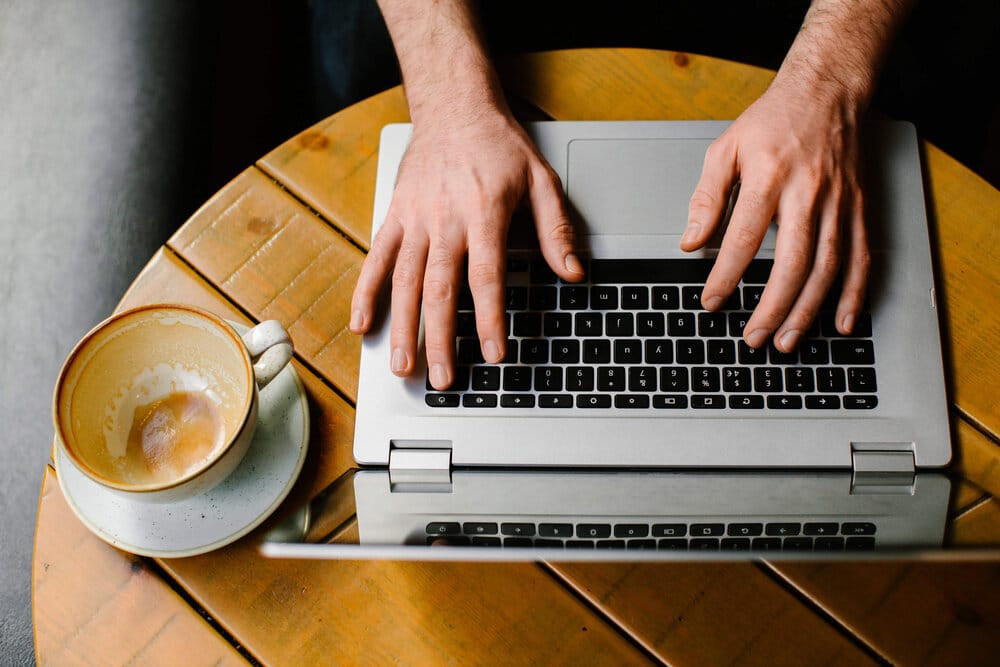 Simon Harper works on his laptop after drinking his cup of black coffee.