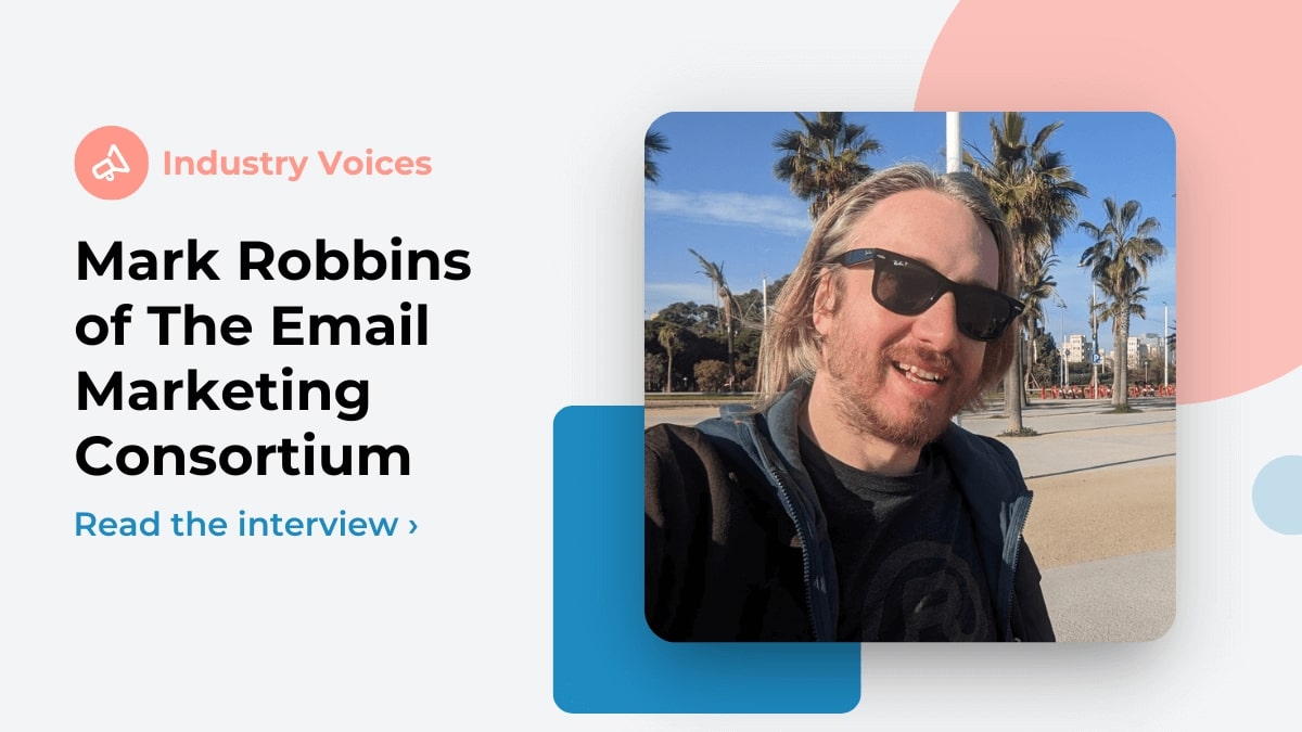 Mark Robbins of the Email Markup Consortium is shown on a white background with pastel shape elements. In our Industry Voices interview he discusses email accessibility. Robbins is wearing sunglasses with palm trees behind him.