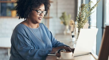 young african-american woman working at computer looking at email newsletter signup form examples