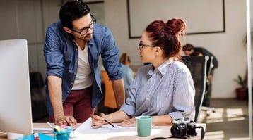 male and female colleagues working on email marketing projects in front of computer