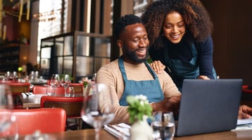 african-american couple smiling in front of computer learning how to build an email list for their business