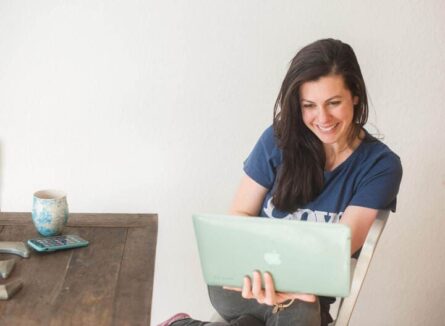 Email expert Emily Ryan looks at her laptop in a well-lit room.