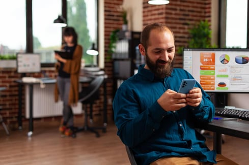 Man looks at smart phone perfects his cold email outreach.