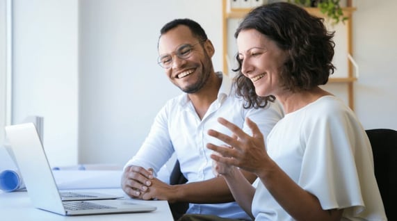 Couple look at Cyber Monday deals in front of a computer.