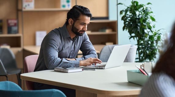 caucasian man working on computer and reading about the aida model in marketing