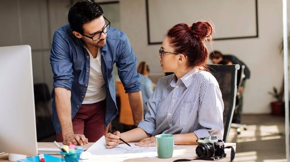 male and female colleagues working on email marketing projects in front of computer