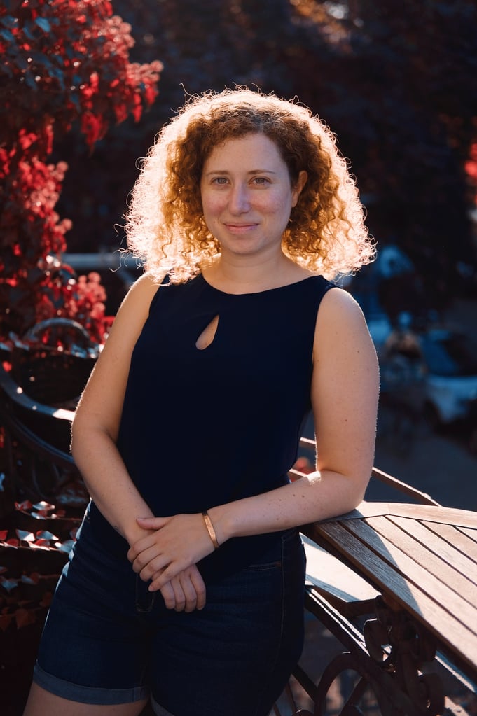 yuval ackerman wearing black shirt on nature background with red trees