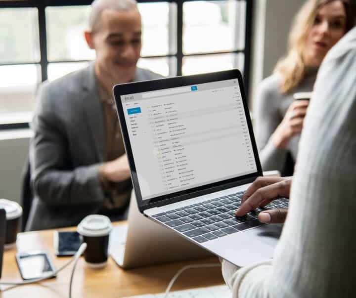 person discussing email marketing with two other people.